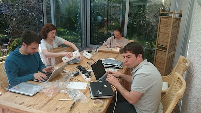 4 Menschen sitzen mit Laptops an einem Tisch