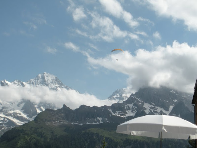 Person parasailing over Mürren Town in Switzerland