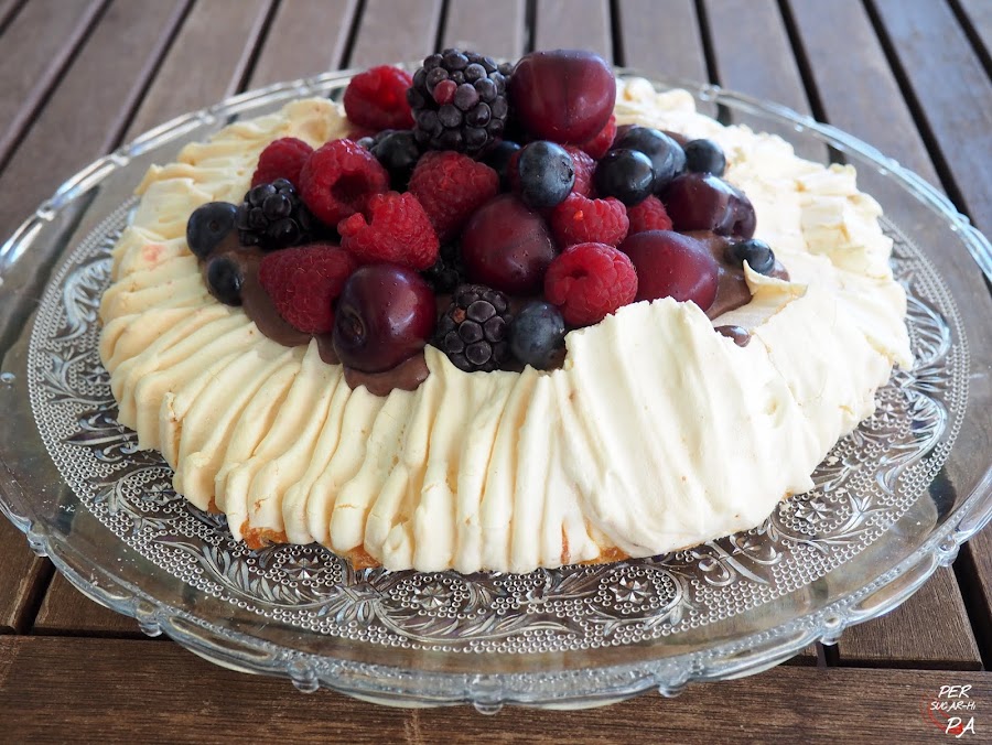 Pavlova, tarta de merengue horneado, rellena de crema de trufa y coronada por frutos rojos variados.