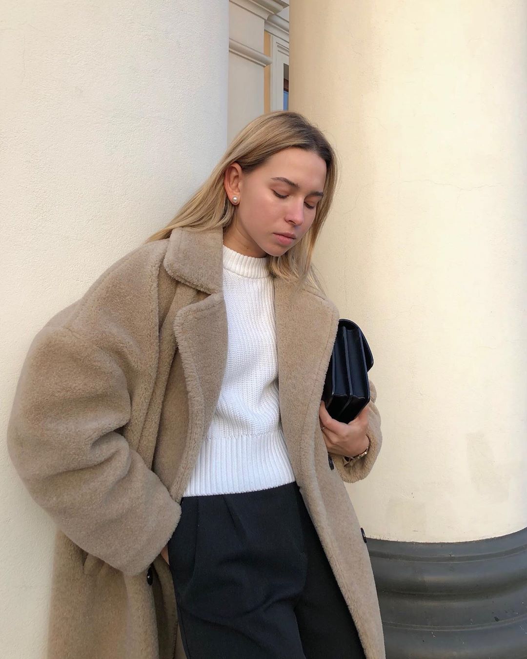 Cozy Yet Elevated Fall and Winter Outfit Idea — @mikhailova_maria In a Teddy Coat, White Knit Sweater, Black Clutch Bag, and Black Pants