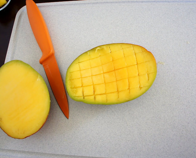 A big slice of mango with lines making cubes cut into it