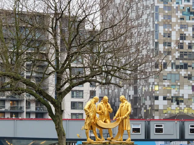 Golden statue of Matthew Boulton, James Watt and William Murdoch in Birmingham, England