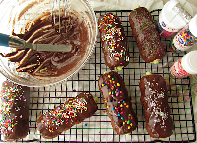 Chocolate doughnuts covered with sprinkles on a wire rack