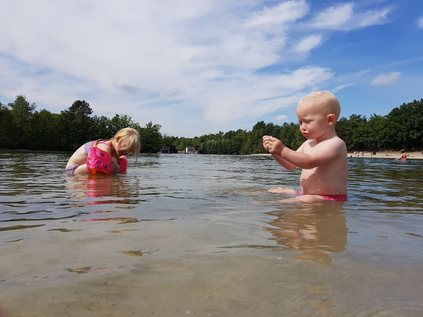 Two children sitting in a lake and playing