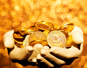 Unas manos con un puñado de monedas de oro