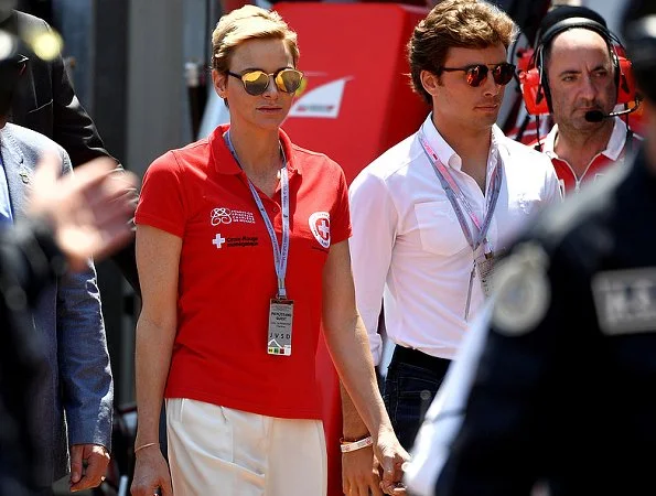 Prince Albert and Princess Charlene at Formula 1 Grand Prix. Princess Charlene wearing the T Shirt of the red cross of Monaco