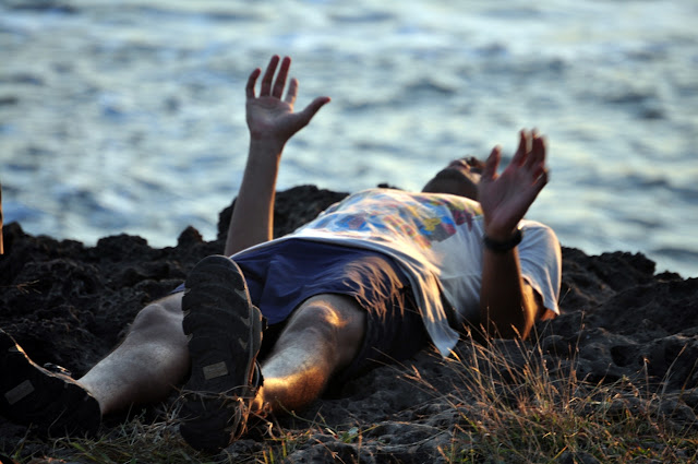 Diu Indian male man lying down beach shorts helpless 