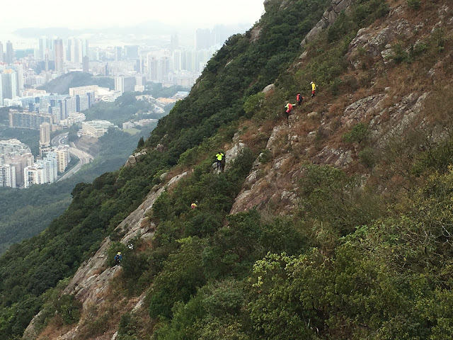 登上獅子山頂之際，有行山隊正從獅子山山肚下降至市區，這段路比走獅尾脊更險要難行