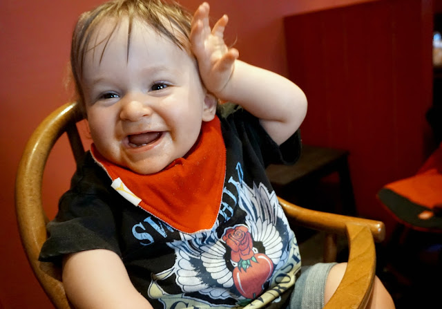 baby boy sitting in highchair and making a funny face