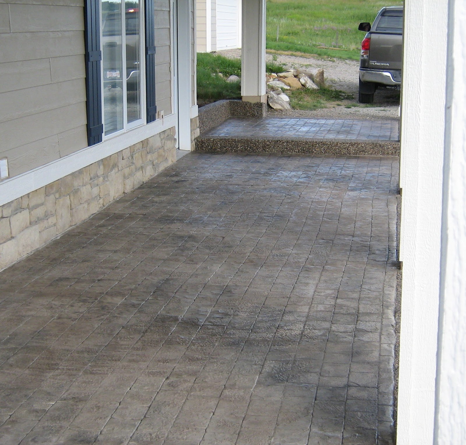 Sundre Concrete Works Walkout patio in cobblestone with exposed aggregate border. Colour; sandstone
