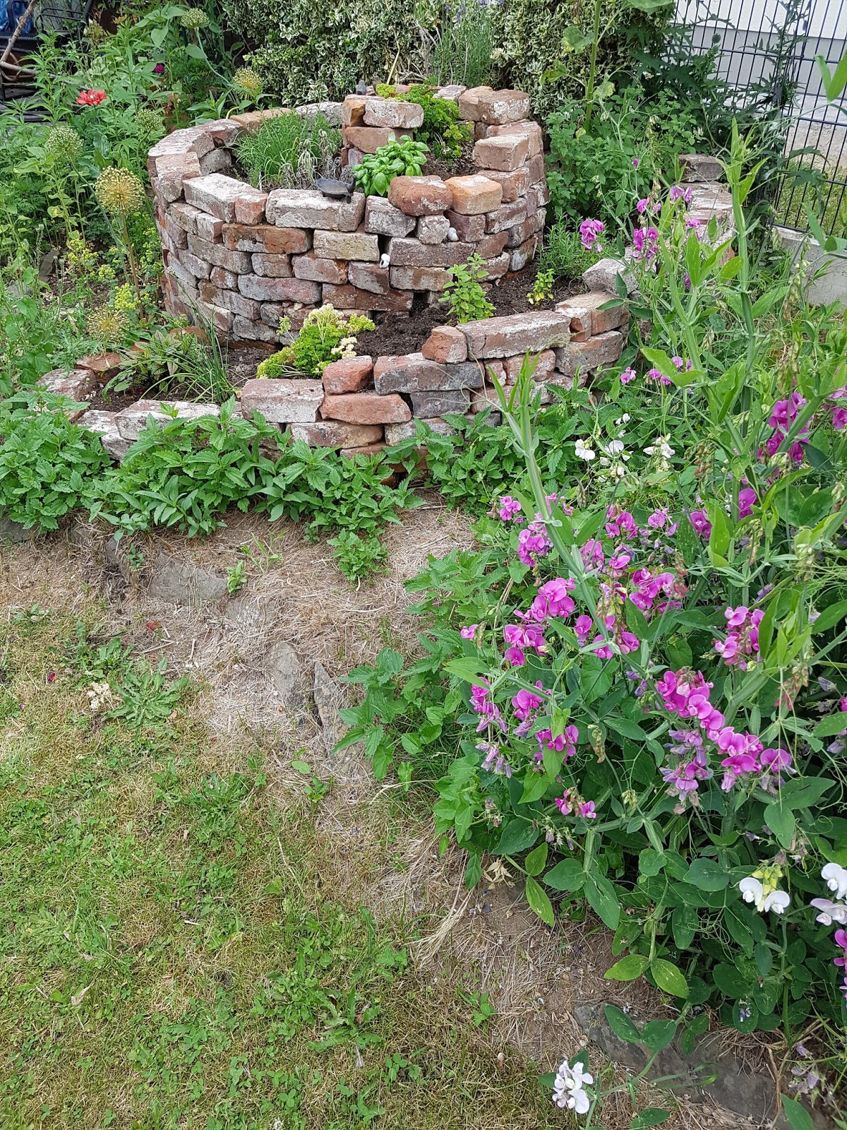 Zange und Hammer Kräuterspirale aus alten Backsteinen