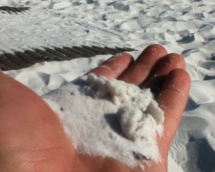 Weißer Sand in der Hand am Strand von Grayton Beach State Park, Florida