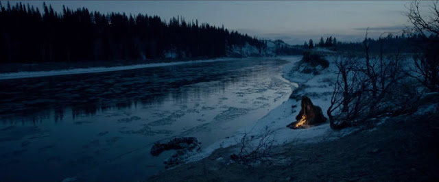 Paisaje de Alaska y protagonista con hoguera en orilla de rio