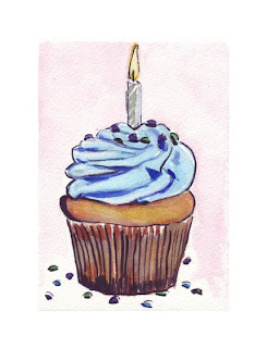 yellow cupcake with blue icing and one candle