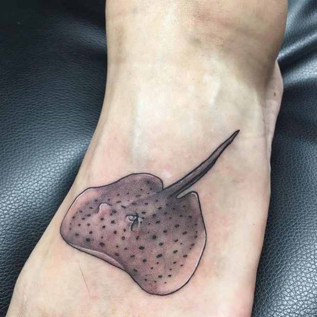 tatuaje de mantarraya en el empeine de un pie