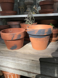 Age new clay pots by adding splashes of black paint for DIY craft project.