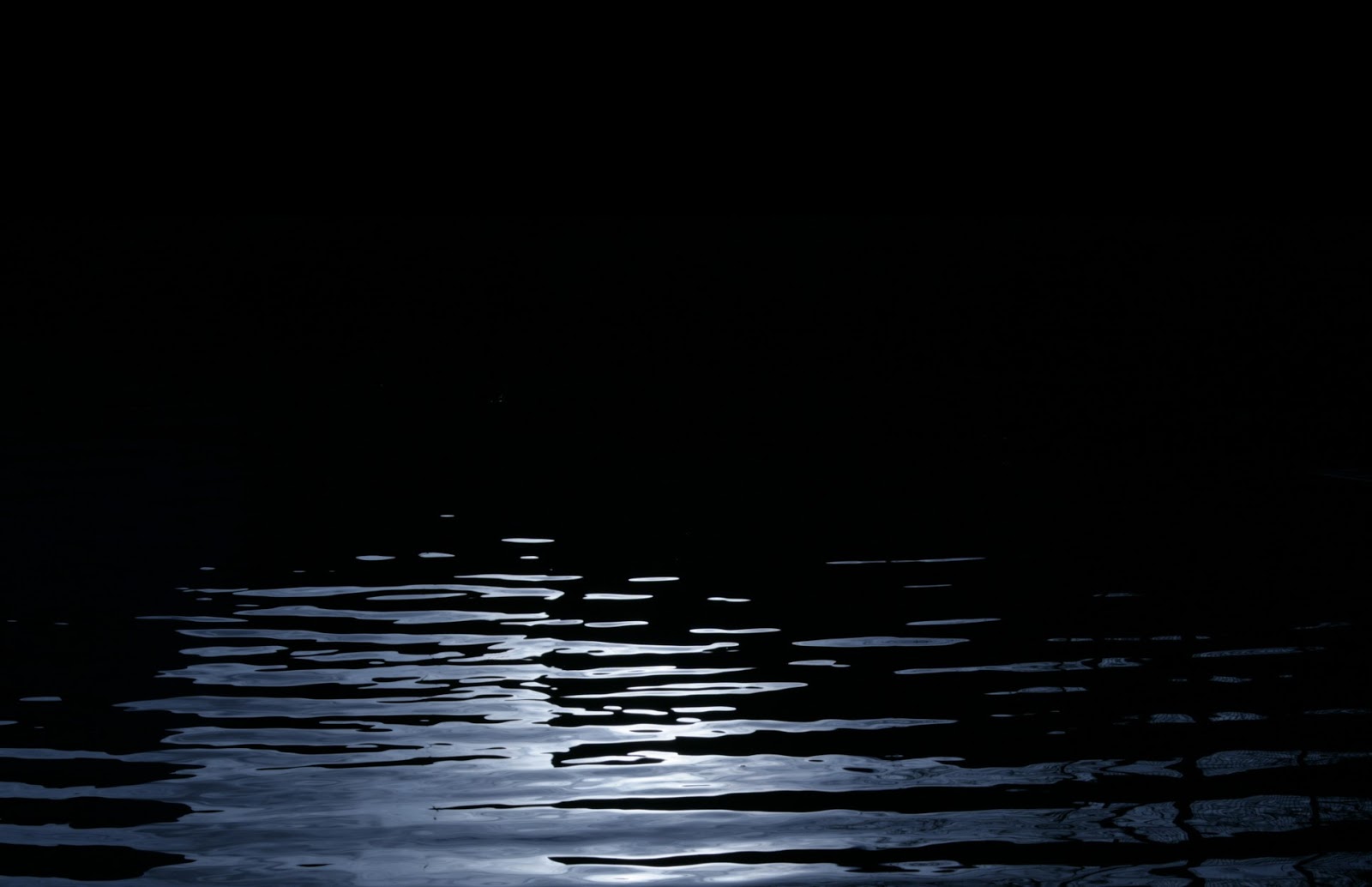 Черная вода далеко. Темные воды. Черная вода. Вода на черном фоне. Лучи в воде на черном фоне.