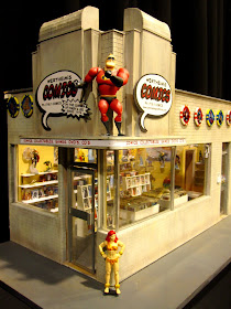 Front view of a modern dolls' house miniature comic book shop in an art deco building