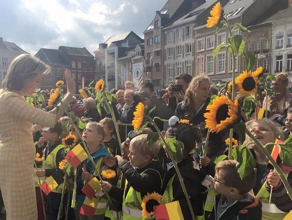 Queen Mathilde of Belgium in a Tan with yellow dress over yellow angora coat