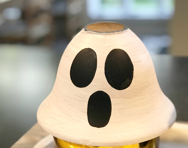 Add a spooky ghost face to an old repurposed lamp globe