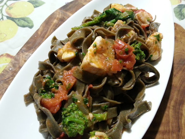 Tagliatelle al nero di seppia con gallinella di mare, pomodorini e cime di rapa.