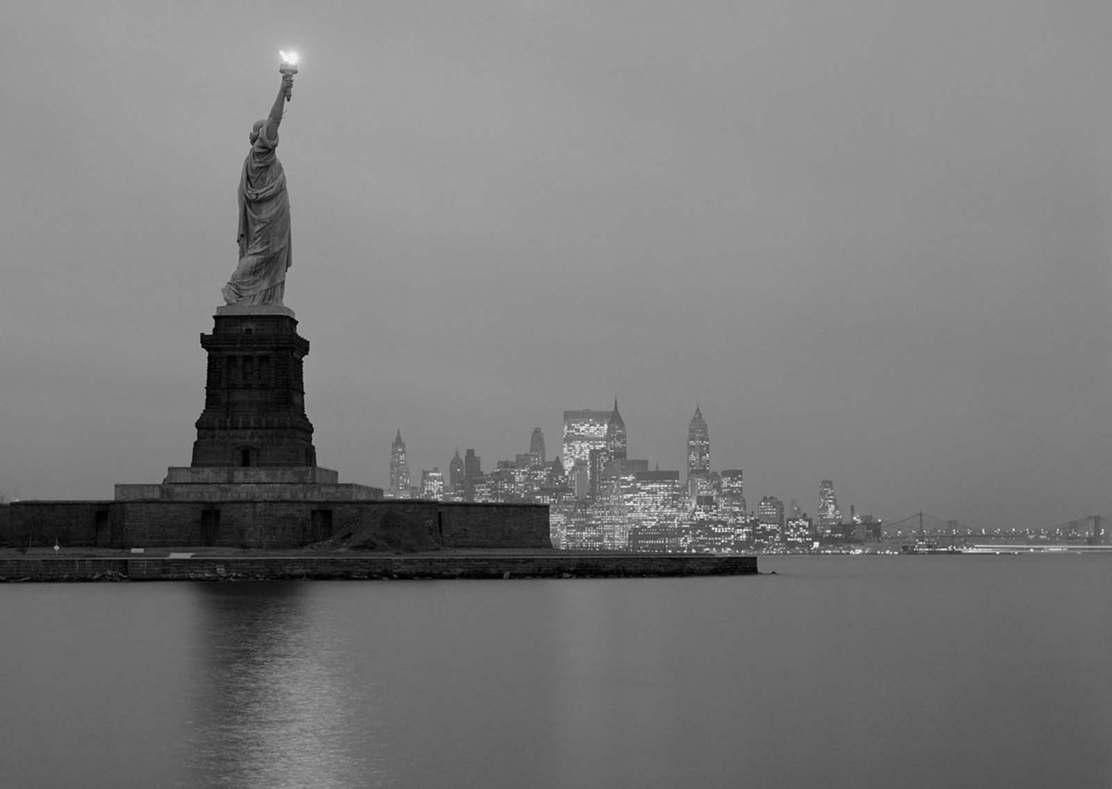 A view of the Statue of Liberty and Manhattan in the evening, photographed in 1961.