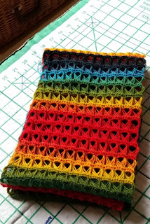 The cowl is finished and folded like a concertina in three layers, resting on the blocking board which is white with a green 1-inch grid.