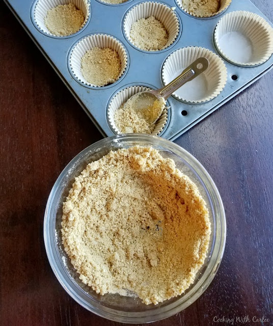 putting graham cracker crust into cupcake liners for s'mores cupcakes