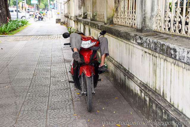 Ein Vietnamese beim Mittagsschlaf auf seinem Moped