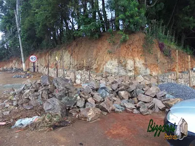 Execução do muro de pedra com pedras rústicas sendo tipo pedra moledo na face da frente do muro e o enchimento com pedra rachão. Muro de pedra na cidade de Joanópolis-SP com tipo de assentamento de pedra com junta seca sem massa.