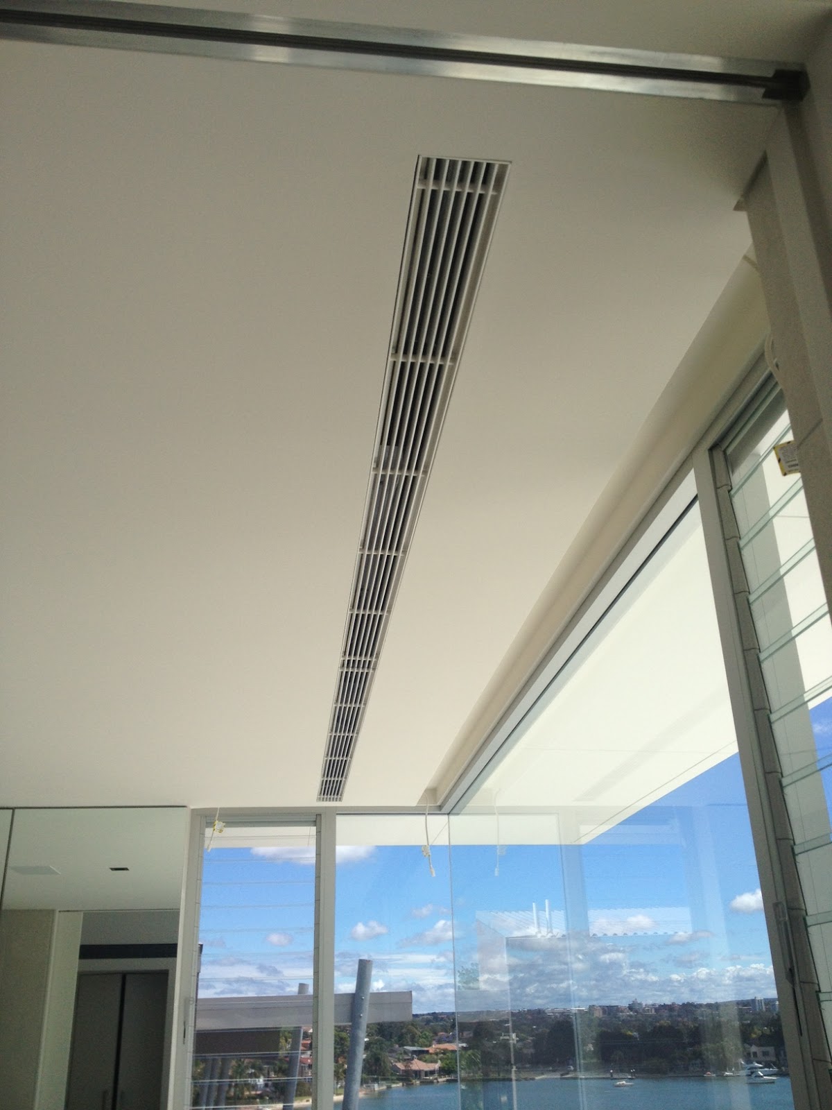 Premium flangeless linear ducted air conditioning grille integrated flush into a modern ceiling