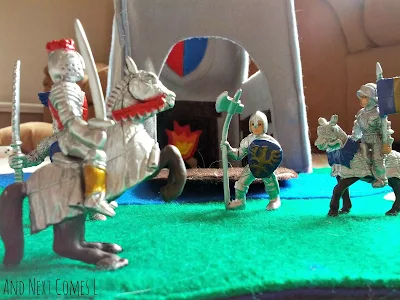 Close up of knights and dragons figures on the felt castle play tote from And Next Comes L