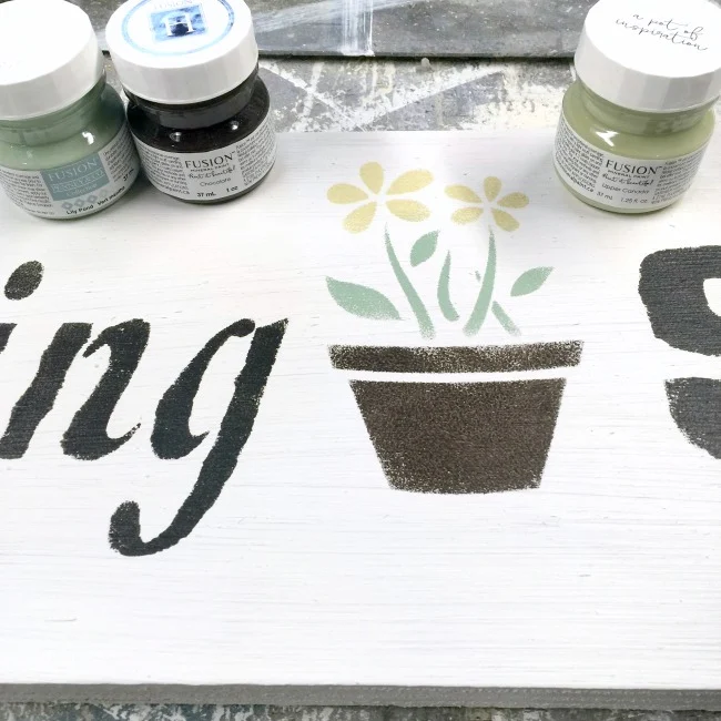 Stenciling a garden sign with sample paints