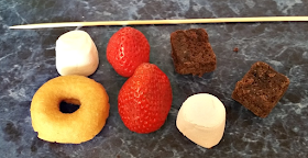 a mini doughnut, strawberries, marshmallows, brownies and the wooden skewer