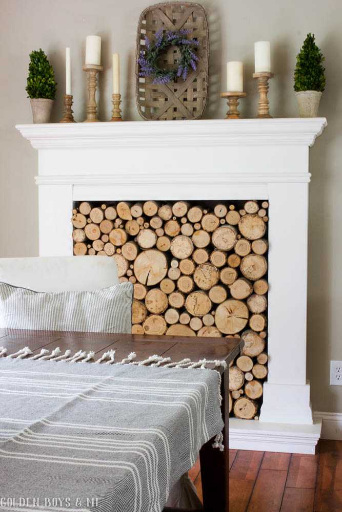 DIY faux fireplace with stacked wood and tobacco basket mantel decor
