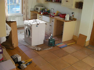 partially tiled kitchen in middle of builders job contractor refit of kitchen tiles washing machine