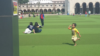 seorang anak dengan ceria berlari bermain di alun alun bandung