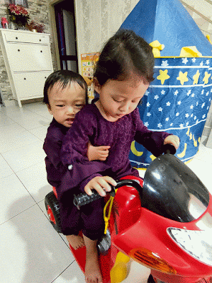 gambar animasi dua budak lelaki dan perempuan menunggang motosikal mainan