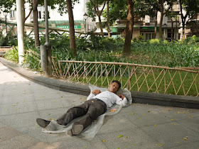 man sleeping on the ground at Lianhua Square in Foshan