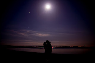 Lovers kissing under a supermoon