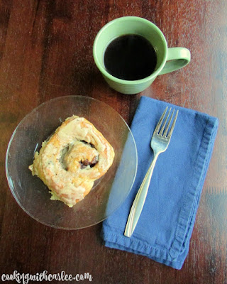 These Coffee and Cream Cinnamon Buns are going to knock your socks off! Breakfast just got better! #SundaySupper coffee and cream cinnamon roll on plate with cup of coffee and fork nearby