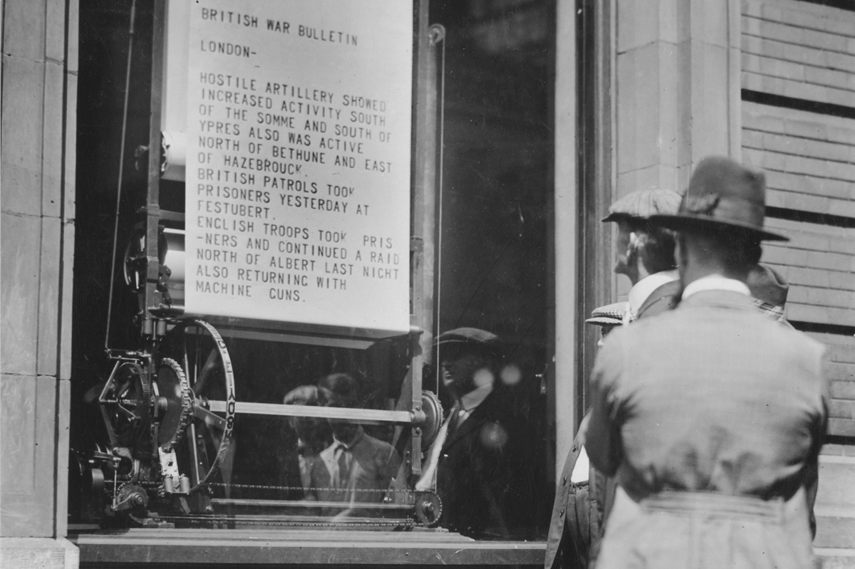 Original caption: War news printed right before your eyes is the latest method of displaying bulletins by big newspapers. The mechanical bulletin printing machines in the window of a Cincinnati newspaper. It is a linotype machine and a printing press combined. 