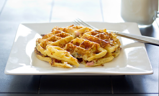 two waffles with cheese and ham on a white plate