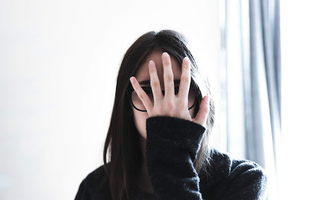 Girl covering face with hand