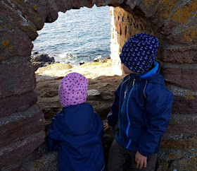 Bornholm mit Kindern im Herbst. Teil 3: 10 tolle Ausflugsziele für Familien auf Dänemarks Sonneninsel. Die Geschwister gucken auf Frederiksö durch eine Schießscharte aufs Meer.