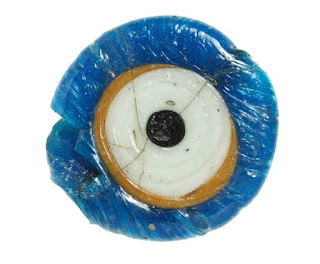 Glass Amulet Eye Circular glass eye - blue round the outside edge with black dot for pupil in centre