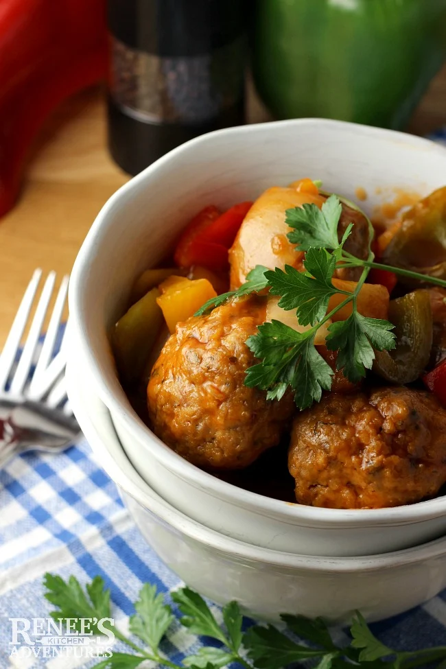 Sweet and Sour Ground Pork Meatballs by Renee's Kitchen Adventures in a white bowl, ready to eat with pepper grinder in the background