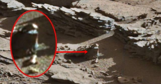 Humanoid being with conehead spotted walking on Mars surface