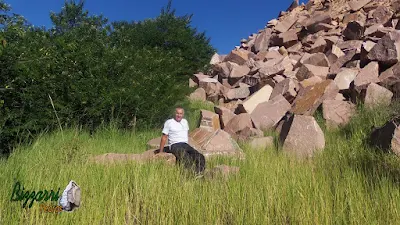 Bizzarri, da Bizzarri Pedras, fazendo o que gosta, garimpando pedra na pedreira. Na foto, escolhendo pedras de granito vermelho, sendo pedras para banco de pedra, mesa de pedra, paisagismo com pedras, escada de pedra, todas essas relíquias de pedra. Verdadeiras peças únicas que vão ser enterradas manualmente com terra boa e transformando essa área em mata nativa. Da dó de ver essa pedra bruta, tantas construções com pedras que da para fazer com essas pedras.