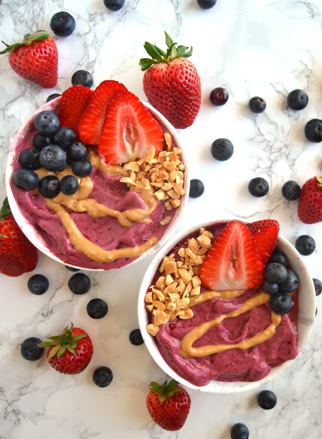 Peanut Butter and Jelly Smoothie Bowls features a thick blueberry smoothie topped with drizzled peanut butter, fruit and crunchy peanuts for the perfect breakfast or snack. www.nutritionistreviews.com
